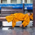 Moine bouddhiste dormant à la gare de Bangkok, Thaïlande